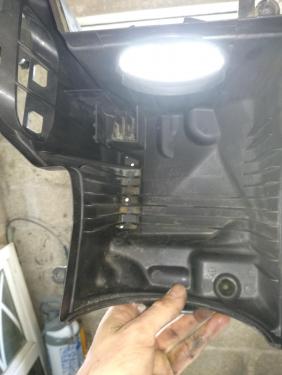 Airbox held up to the light showing 3 tiny holes.jpg